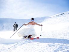 A bride and groom skiing on there wedding day