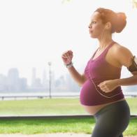 Pregnant mixed race woman power walking in park
