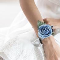 Beautiful flower bracelet on bridesmaid's hands. Focus on light blue flower bracelet, Selective focus.