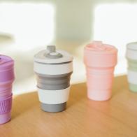 A set of multi-colored folding silicone cups for drinks without plastic in a waste-free style on the background of the interior, close-up. Product photography. Store content.