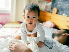 Morning Mood Asian baby wake up early before daddy and playful on the bed