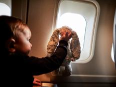 Boy Wit Stuffed Animal On Airplane.