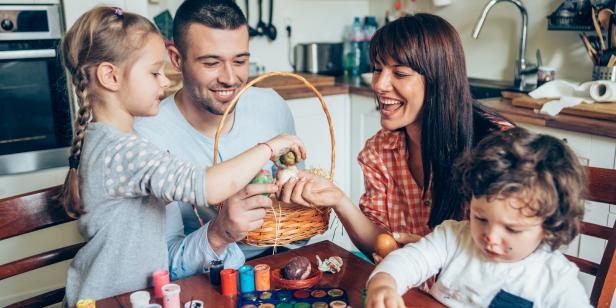 Happy family and their Easter Basket with Colored Eggs