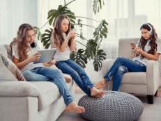 Education, friendship, technology and children concept. Group of teenage girls is using gadgets. Kids with phones and tablets, with smartphones and headphones.