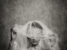 ghostly bride raising her veil - toned image, added grain, texture, vignetting