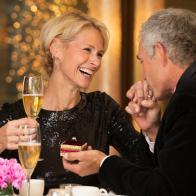 Caucasian man giving ring to wife in restaurant