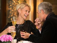 Caucasian man giving ring to wife in restaurant