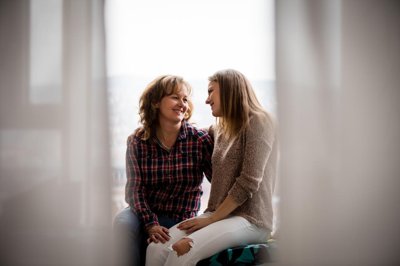 Affectionate smiling mother and daughter facing each other. 