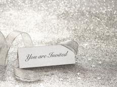 'You are Invited' silver place card. Shallow depth of field, glitzy background, blank version available.
