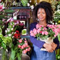 florist tending to tulips, roses, lilies, and hydrangeas