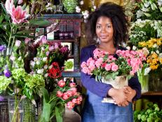 florist tending to tulips, roses, lilies, and hydrangeas