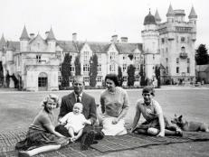 Royalty, 9th September 1960, During their holiday on the Balmoral Castle estate the Royal family sit together within the grounds, a happy smiling baby Prince Andrew held on his father the Duke of Edinburgh+s lap, Pictured also smiling is Queen Elizabeth II with Princess Anne and Prince Charles and their Corgi dogs that are with them also  (Photo by Popperfoto/Getty Images)