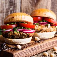 Vegan meal. Chickpea veggie burger with fresh vegetables on rustic cutting board