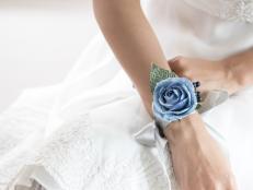 Beautiful flower bracelet on bridesmaid's hands. Focus on light blue flower bracelet, Selective focus.