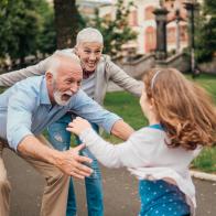 Senior couple spreading their arms for the child running towards them