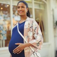 Portrait smiling pregnant woman outside storefront