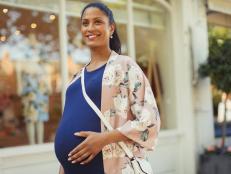 Portrait smiling pregnant woman outside storefront