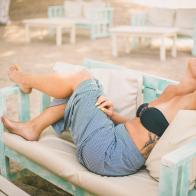 Blond girl relaxing on beach bed.