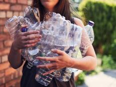 Young woman recycling plastic bottles