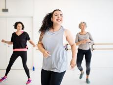 Young woman learning dance moves in fitness class. Multi-ethnic women dancing in studio.