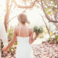 Caucasian bride and groom holding hands outdoors