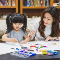 Asian girl kid and mother doing drawing with many colour pencils on white paper