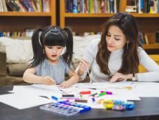 Asian girl kid and mother doing drawing with many colour pencils on white paper