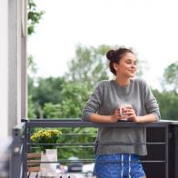 Young woman drinking morning coffee on the balcony
