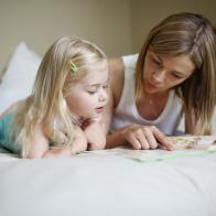 A mom and her daughter reading a book