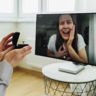 Man making marriage proposal to girlfriend by using online video call. Showing the ring to happy woman