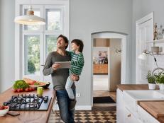 Deutschland, Hamburg, Lifestyle, Familie, Vater mit Sohn steuern Küchenlampe über Tablet-Computer