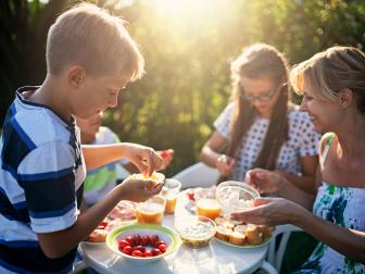 Three kids having fun eating fresh breakfast in the garden.
Nikon D850