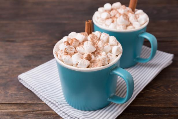 Blue mugs of cocoa, delicious dessert for cold weather or Christmas time. Hot cocoa in cups.