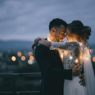 Romantic newlyde couple standing on the roof top in the city in the night