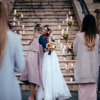 Loving mother embracing elegant bride at outdoors rustic cottage wedding ceremony in Europe