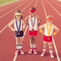 Three little track champions show off their medals.