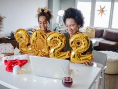 Mother and daughter are at home, they are holding 2020. balloon numbers and communicating on a video call