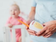 Selective focus of mother holding baby monitor near daughter at background