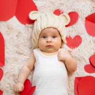 3 month old baby with teddy bear hat and t-shirt photographed with red hearts