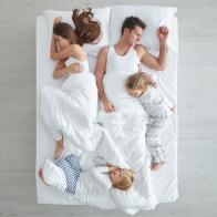 Family sleeping in bed.