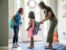 Mother packing daughters backpacks for school