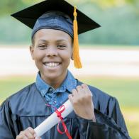 Portrait of cheerful African American male elementary school graduate