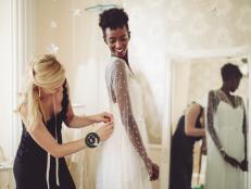 Fashion designer is adjusting the wedding dress