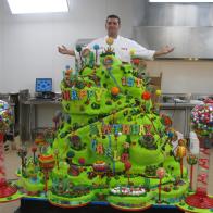 Wide shot of finished Carlo s Birthday cake, Buddy stands behind. 