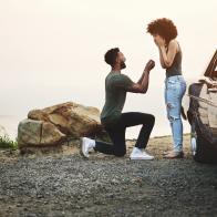 Shot of a young man proposing to his girlfriend during a road trip