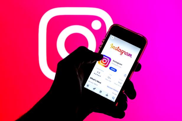 SPAIN - 2021/03/29: In this photo illustration, the Instagram app in App Store seen displayed on a smartphone screen and a Instagram logo in the background. (Photo Illustration by Thiago Prudencio/SOPA Images/LightRocket via Getty Images)
