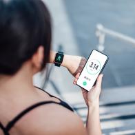 Close-up shot of woman checking her smart watch and mobile phone after run