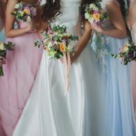 Bride and bridesmaids. Beautiful young women in dresses and with bouquets of fresh flowers.