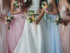 Bride and bridesmaids. Beautiful young women in dresses and with bouquets of fresh flowers.