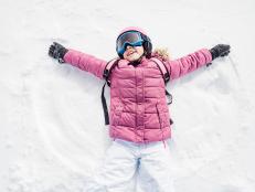Little girl playing snow angel